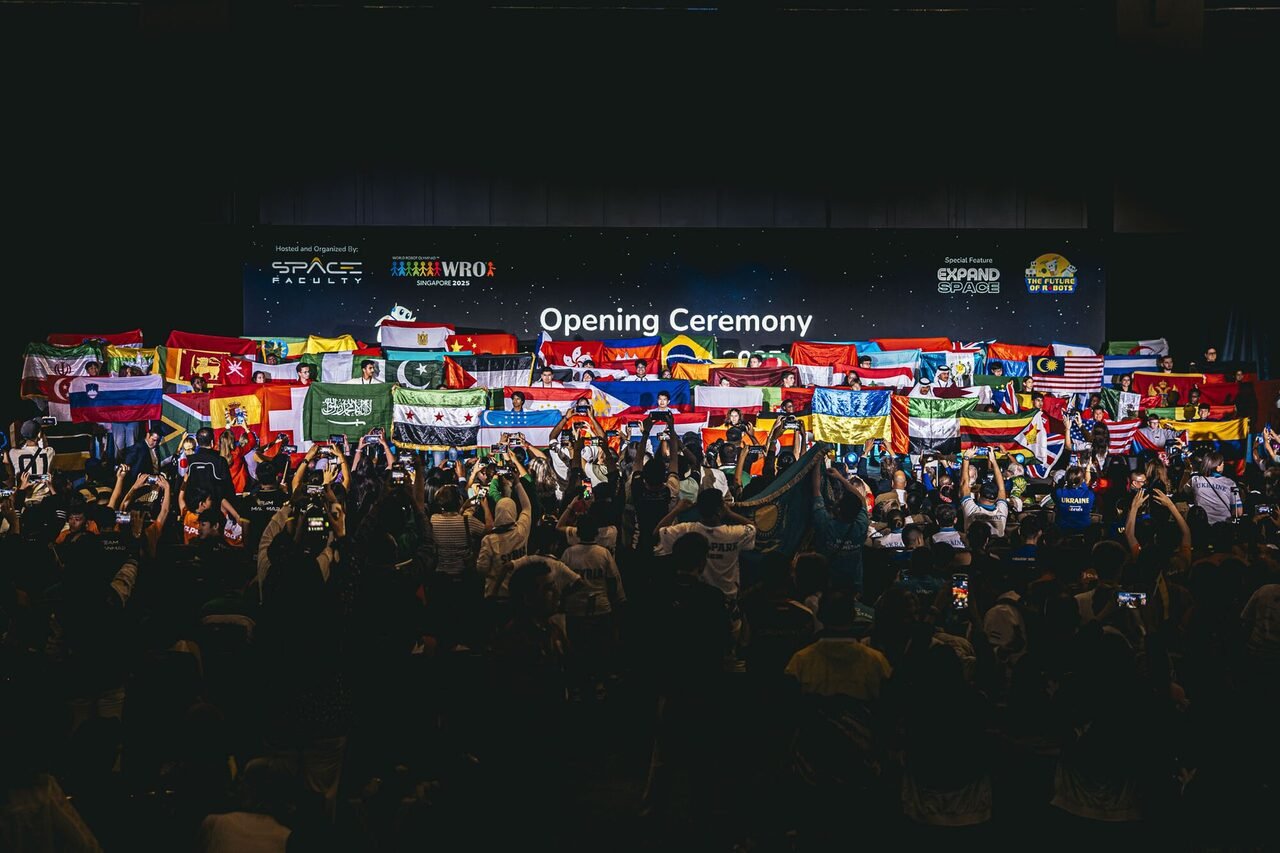 Ceremonia de apertura de la final mundial de World Robot Olympiad: las delegaciones sostienen las banderas de sus países frente al escenario.